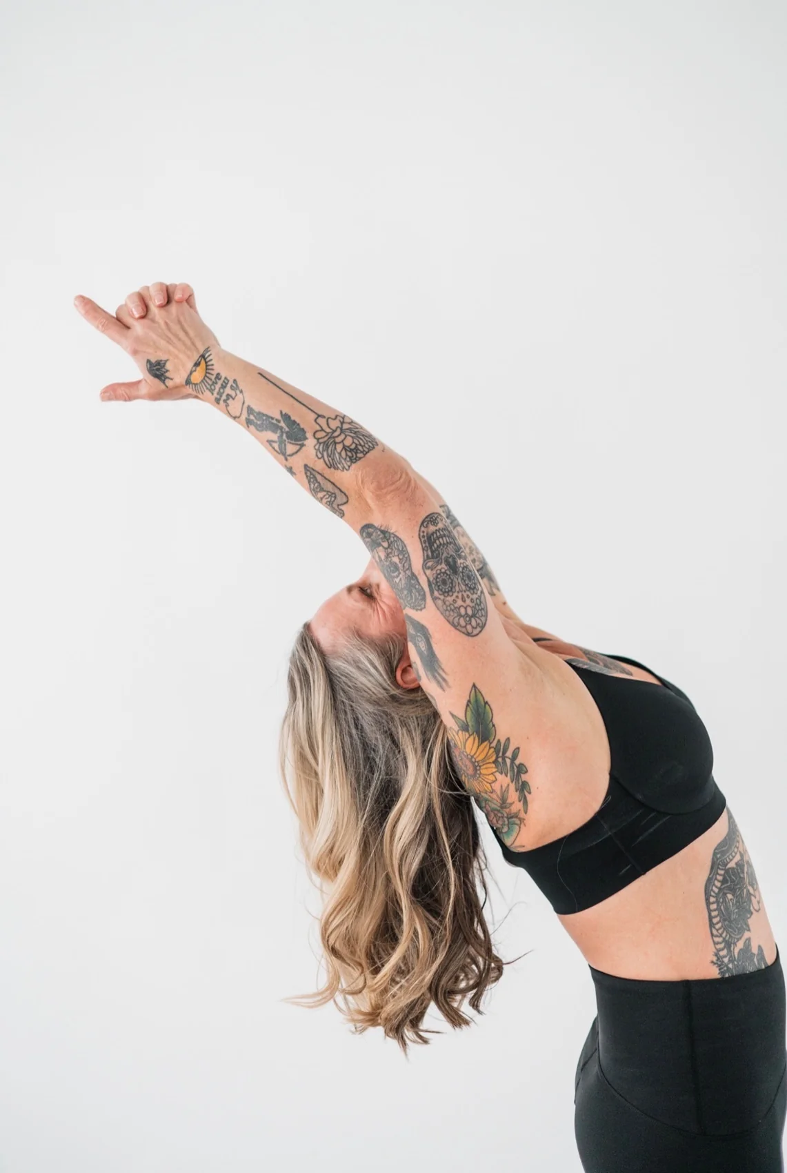 Jennifer Dessert reaching her arms overhead in a yoga posture.