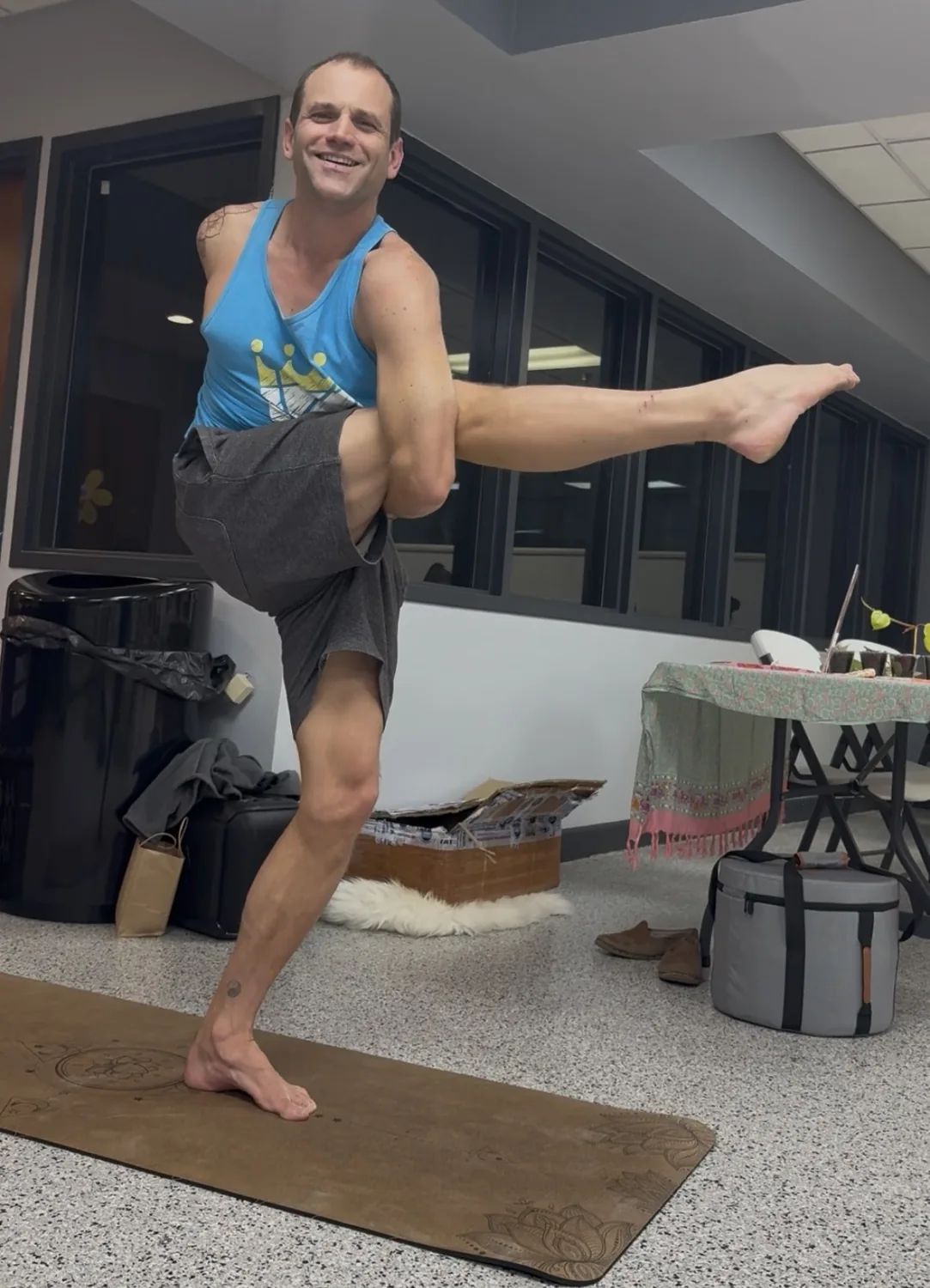 Shawn Lillig balancing on one leg on a yoga mat.
